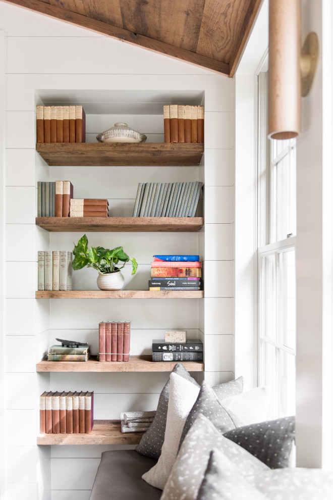 Sullivan's Island Remodel - Dining room featuring light white oak flooring, custom built-in bench for additional seating, bookscases featuring wood shelves, horizontal shiplap walls, and a mushroom board ceiling.