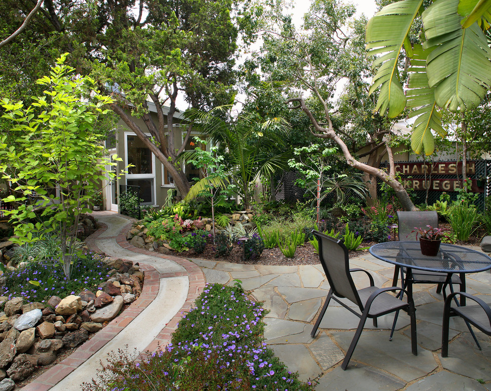 This is an example of a tropical patio in Los Angeles with natural stone pavers.