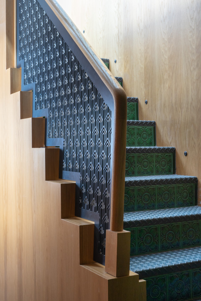 На фото: угловая лестница среднего размера в современном стиле с металлическими ступенями, подступенками из плитки, металлическими перилами и деревянными стенами