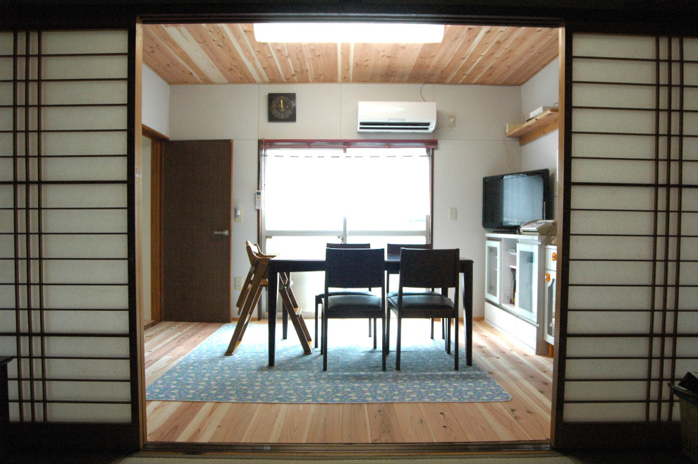 Photo of a mid-sized asian separate dining room in Other with white walls, medium hardwood floors, brown floor and wood.