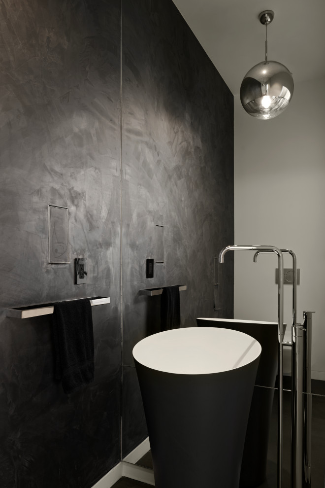 Design ideas for a mid-sized contemporary powder room in San Francisco with a wall-mount toilet, grey walls, porcelain floors, a wall-mount sink, solid surface benchtops, black floor, white benchtops and a freestanding vanity.