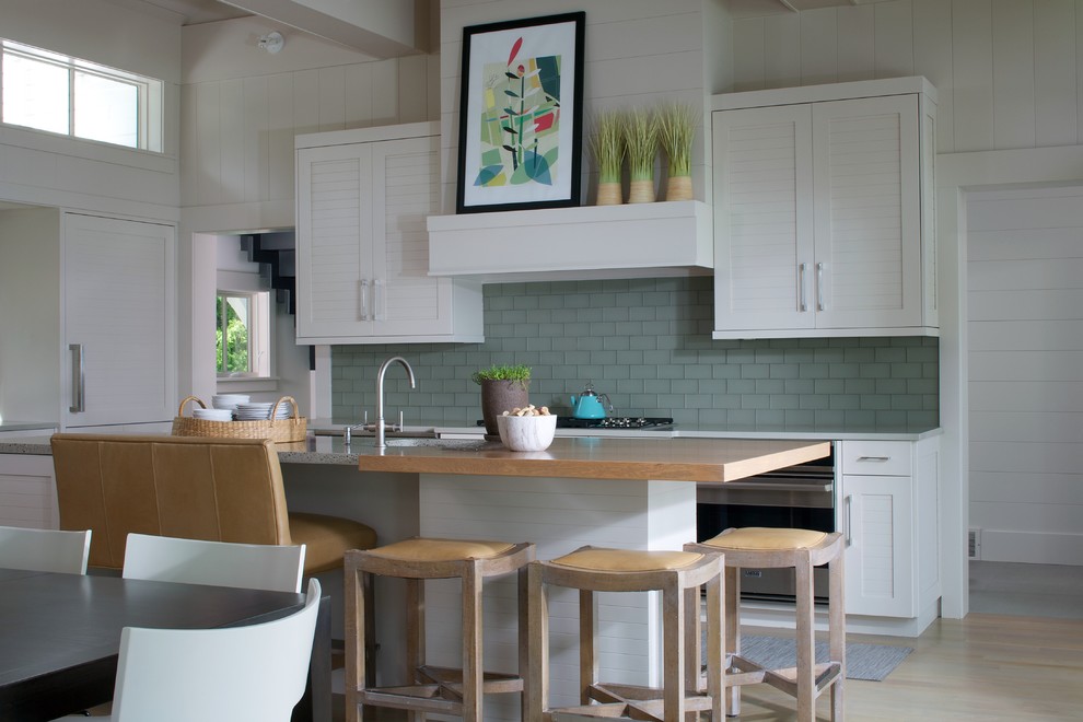 Contemporary eat-in kitchen in Grand Rapids with shaker cabinets, subway tile splashback, wood benchtops, green splashback, an undermount sink, white cabinets, stainless steel appliances, light hardwood floors and with island.