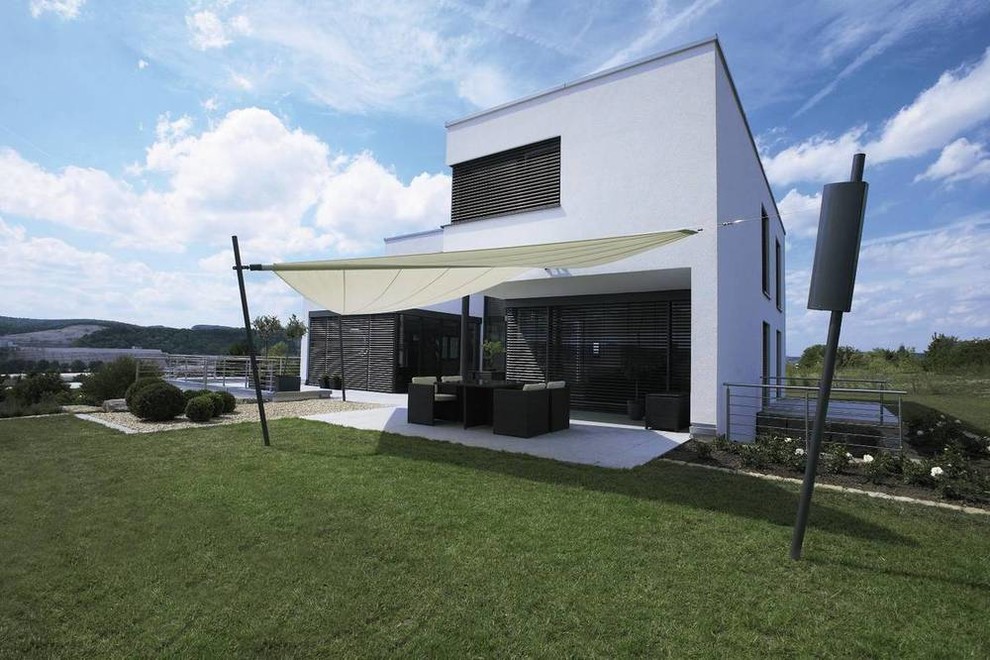 Design ideas for a large contemporary two-storey white exterior in Berlin with a flat roof.