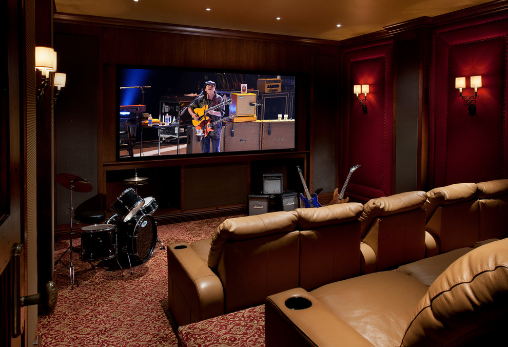 This is an example of a large mediterranean enclosed home theatre in Phoenix with red walls, carpet, a wall-mounted tv and multi-coloured floor.
