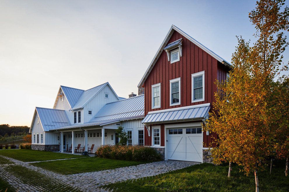 Dreistöckiges Country Haus mit weißer Fassadenfarbe, Satteldach, Blechdach, grauem Dach und Wandpaneelen in Sonstige