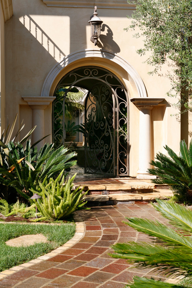 Photo of a mediterranean entryway in Orange County with a single front door and a metal front door.