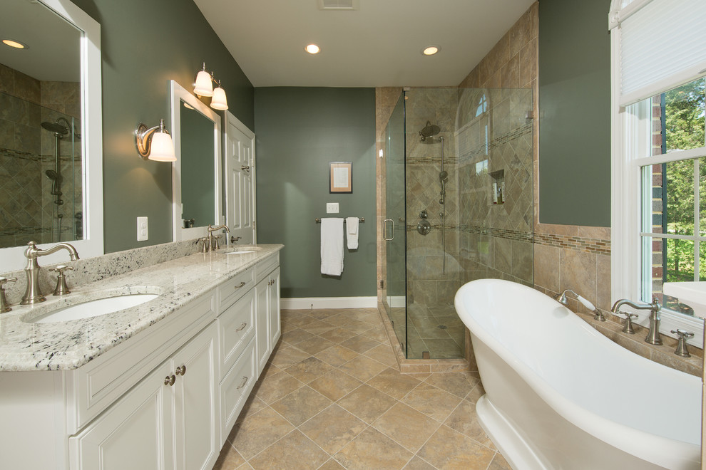 Example of a classic master brown tile brown floor freestanding bathtub design in DC Metro with recessed-panel cabinets, white cabinets, green walls, an undermount sink and a hinged shower door