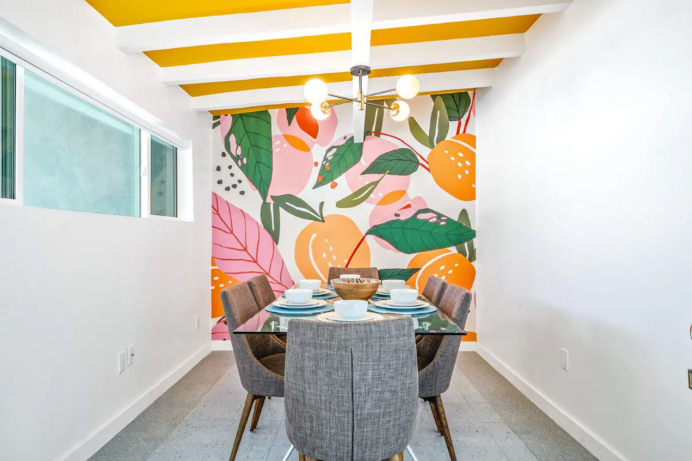 Foto di una sala da pranzo minimalista con pareti multicolore, pavimento in laminato, pavimento blu, travi a vista e carta da parati
