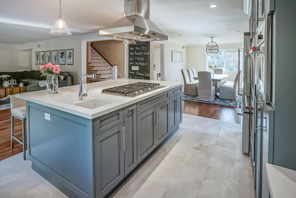 Design ideas for a large transitional l-shaped open plan kitchen in Los Angeles with a farmhouse sink, shaker cabinets, grey cabinets, quartz benchtops, grey splashback, marble splashback, stainless steel appliances, porcelain floors, with island and white floor.