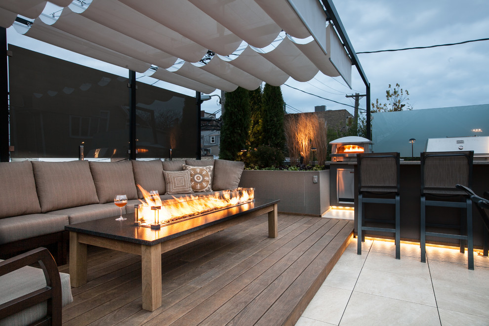 Photo of a mid-sized rooftop deck in Chicago with an outdoor kitchen and a pergola.