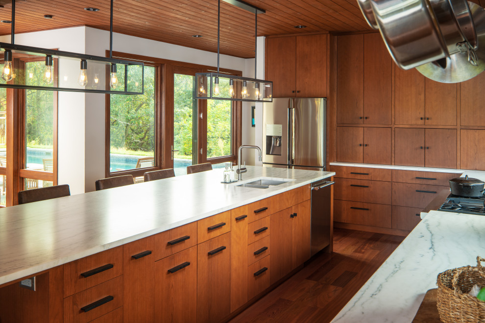 Large country galley eat-in kitchen in Omaha with an undermount sink, flat-panel cabinets, medium wood cabinets, marble benchtops, white splashback, marble splashback, stainless steel appliances, dark hardwood floors, with island, red floor, white benchtop and wood.
