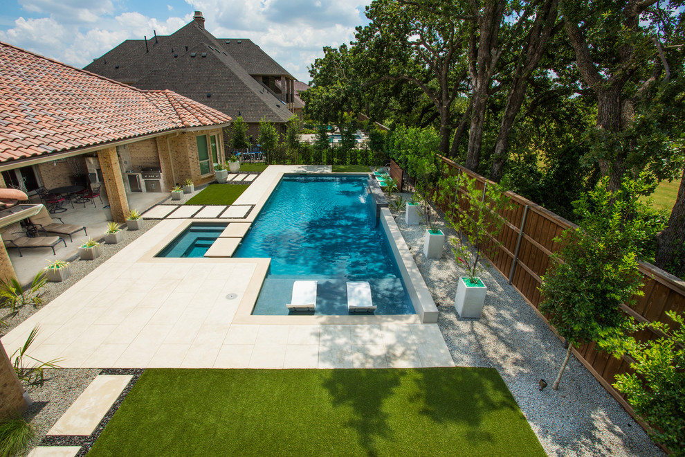 Contemporary backyard rectangular lap pool in Dallas with a water feature and concrete slab.