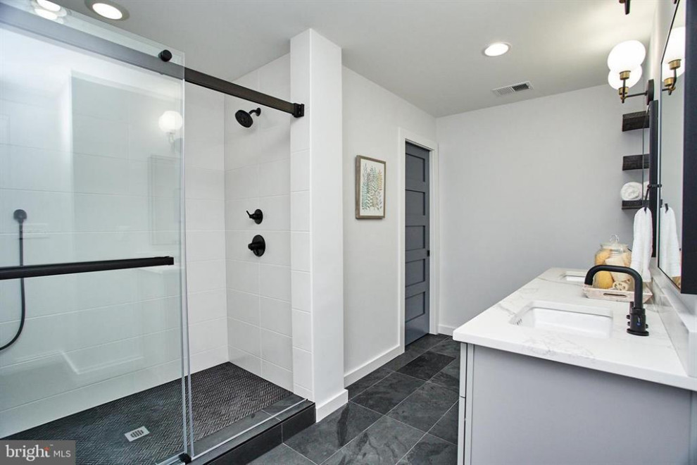 Large contemporary master bathroom in DC Metro with shaker cabinets, grey cabinets, black tile, porcelain tile, grey walls, slate floors, an undermount sink, engineered quartz benchtops, black floor, a sliding shower screen, white benchtops, an enclosed toilet, a double vanity and a freestanding vanity.