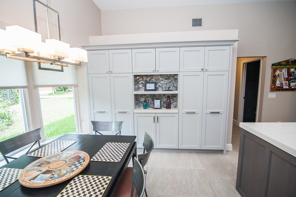 Inspiration for a mid-sized transitional u-shaped porcelain tile and beige floor eat-in kitchen remodel in Miami with an undermount sink, shaker cabinets, gray cabinets, quartz countertops, gray backsplash, glass tile backsplash, stainless steel appliances, an island and white countertops