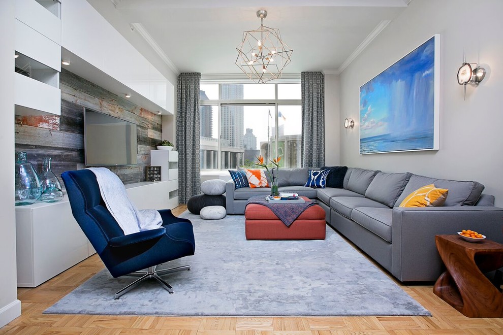 This is an example of a large contemporary open concept living room in New York with grey walls, no fireplace, a built-in media wall and light hardwood floors.