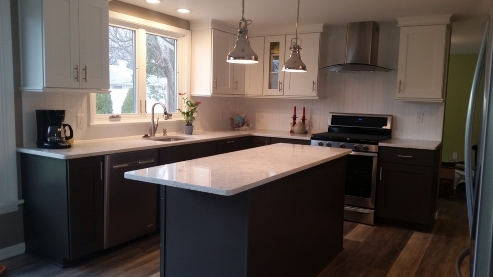 Photo of a traditional eat-in kitchen in Other with an undermount sink, shaker cabinets, white cabinets, quartz benchtops, white splashback, stainless steel appliances, vinyl floors, with island, brown floor and white benchtop.