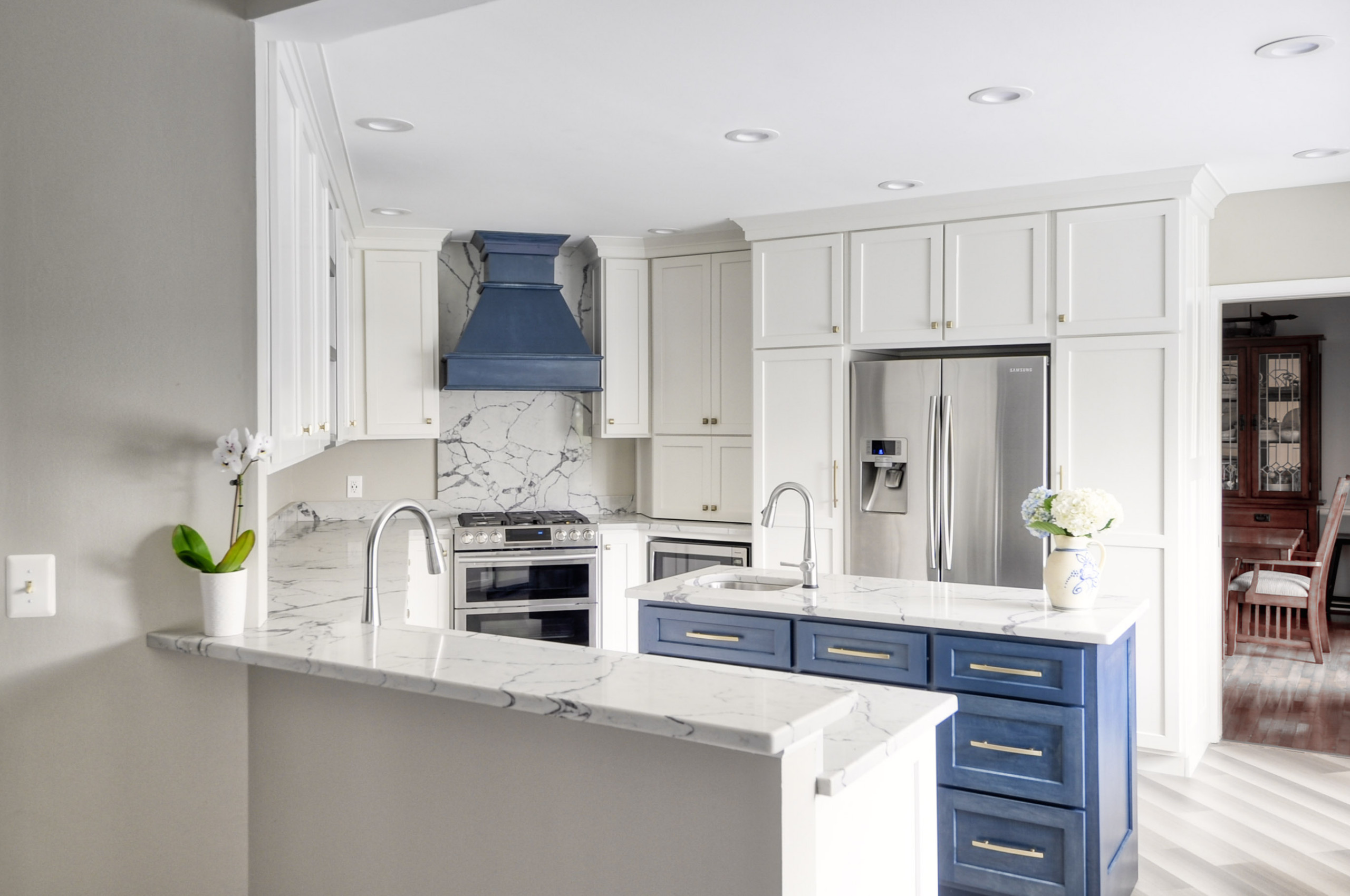 Navy Stained Island, Hood vent and Floating Shelves in White Shaker Kitchen