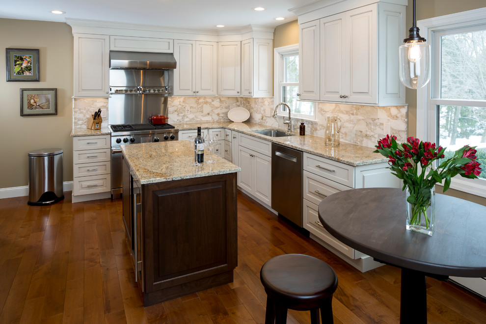 Photo of a mid-sized transitional l-shaped eat-in kitchen in New York with raised-panel cabinets, white cabinets and with island.