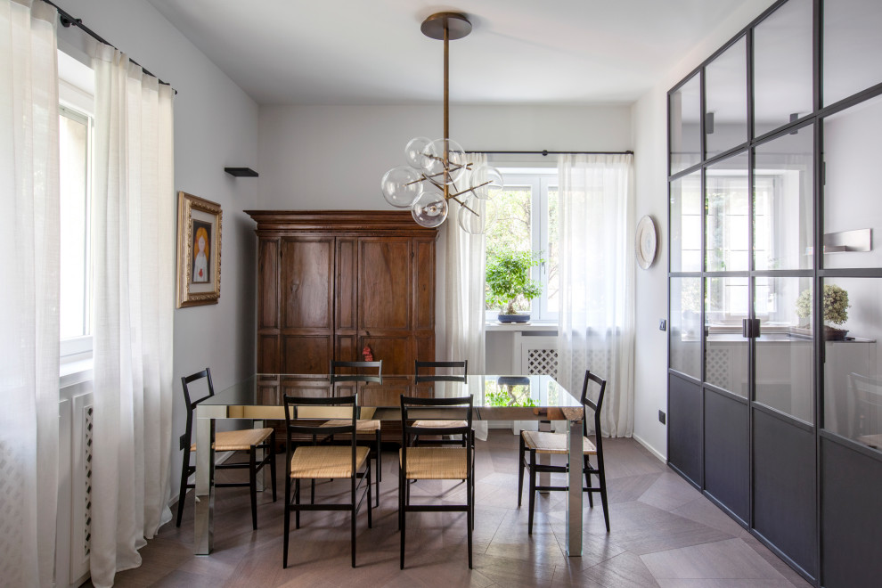 Contemporary separate dining room in Milan with white walls, dark hardwood floors and brown floor.