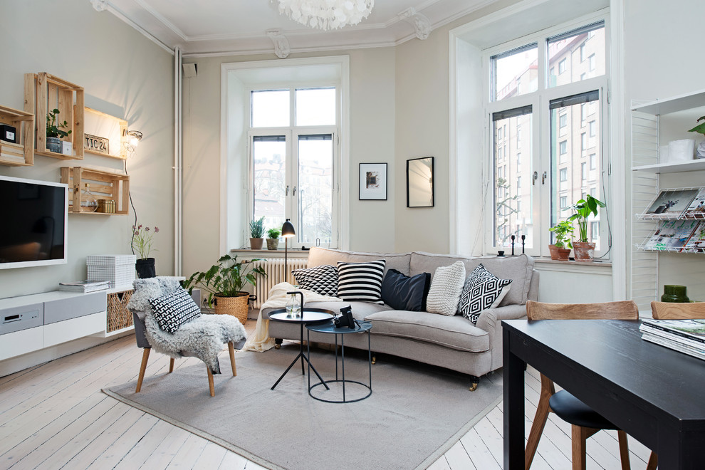 Design ideas for a large scandinavian formal living room in Gothenburg with a wall-mounted tv, beige walls and painted wood floors.