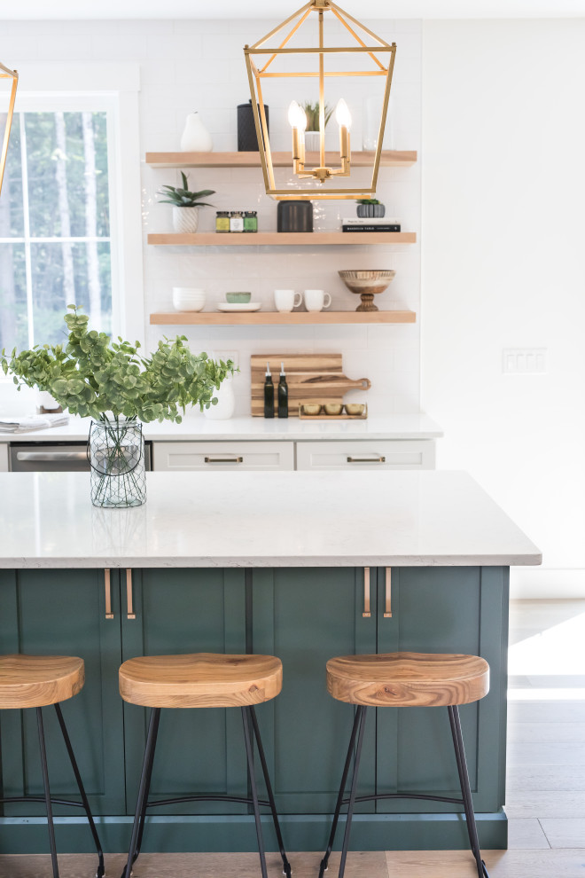Design ideas for a large arts and crafts l-shaped eat-in kitchen in Boston with an undermount sink, shaker cabinets, green cabinets, quartz benchtops, white splashback, subway tile splashback, stainless steel appliances, with island and white benchtop.