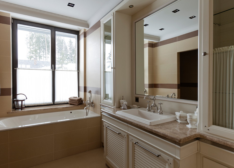 Photo of a traditional master bathroom in Moscow with louvered cabinets, beige cabinets, an alcove tub, beige tile, a drop-in sink, beige floor and beige benchtops.