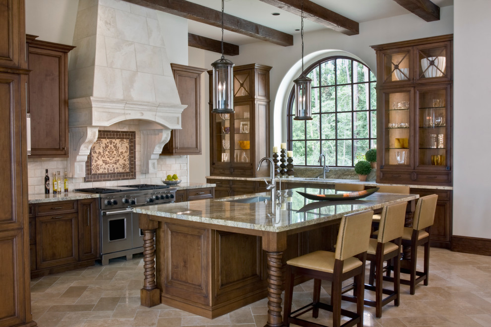 Inspiration for a large mediterranean u-shaped open plan kitchen in Houston with an undermount sink, glass-front cabinets, medium wood cabinets, granite benchtops, beige splashback, stone tile splashback, panelled appliances, travertine floors and with island.