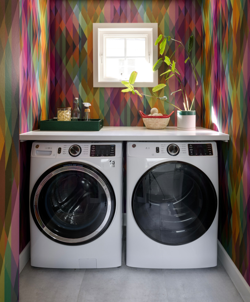 Immagine di una lavanderia chic con pareti multicolore, lavatrice e asciugatrice affiancate, pavimento grigio, top bianco e carta da parati