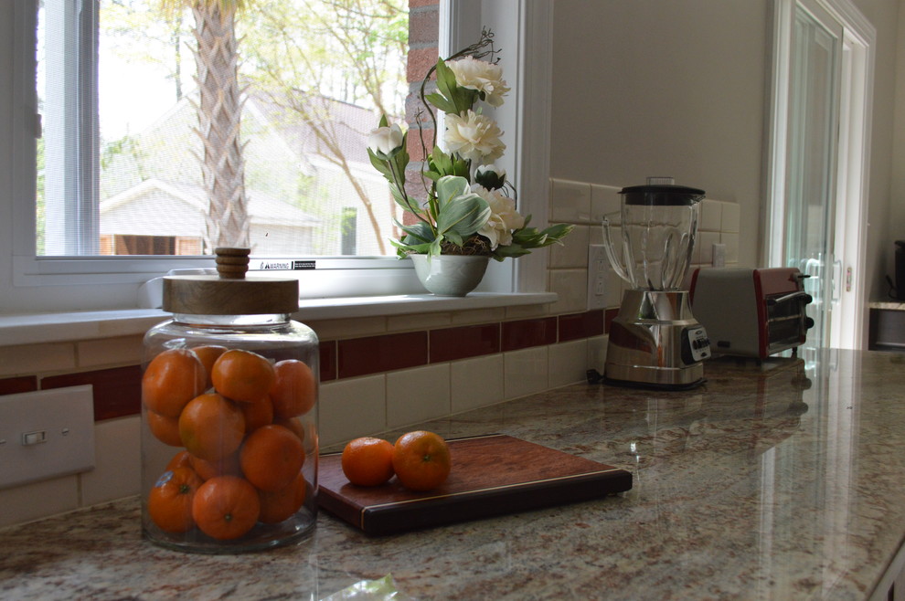 Example of a large transitional l-shaped porcelain tile and beige floor eat-in kitchen design with a farmhouse sink, raised-panel cabinets, brown cabinets, granite countertops, white backsplash, ceramic backsplash, stainless steel appliances and a peninsula