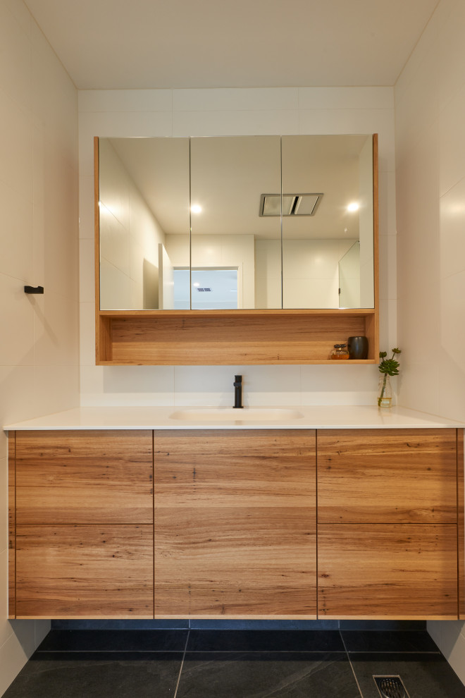 This is an example of a small modern master bathroom in Melbourne with flat-panel cabinets, light wood cabinets, an alcove shower, white tile, ceramic floors, a drop-in sink, white benchtops, a single vanity and a floating vanity.