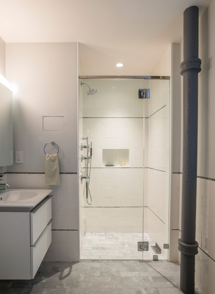 This is an example of a small contemporary 3/4 bathroom in New York with flat-panel cabinets, white cabinets, an alcove shower, white tile, ceramic tile, white walls, brick floors, an integrated sink, solid surface benchtops, grey floor and a hinged shower door.