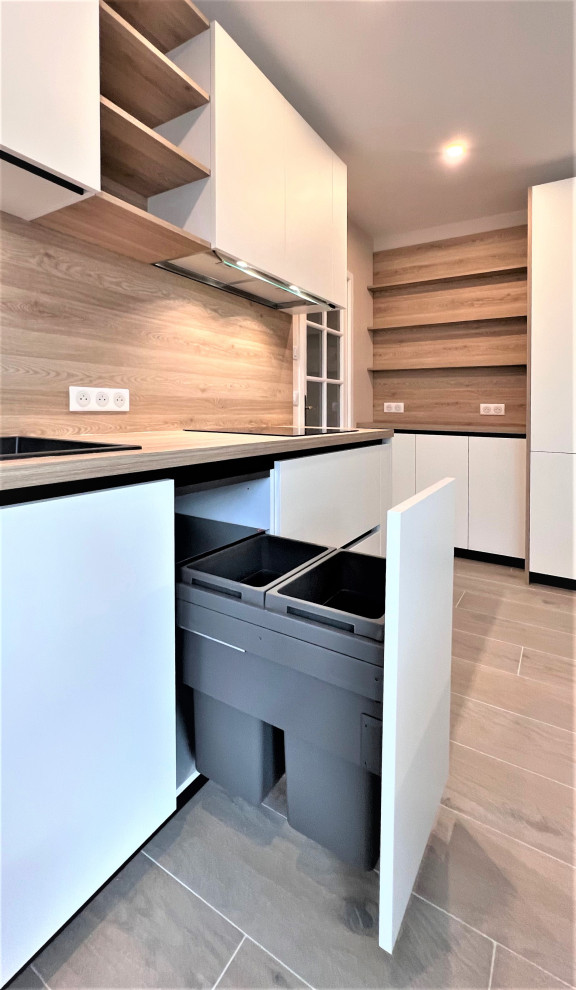 Idéer för mellanstora funkis brunt kök, med en undermonterad diskho, luckor med profilerade fronter, vita skåp, träbänkskiva, brunt stänkskydd, stänkskydd i trä, integrerade vitvaror, cementgolv, en köksö och beiget golv