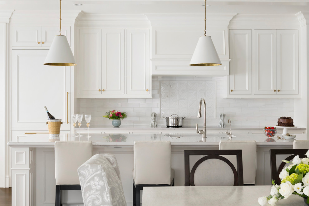 Bild på ett stort vintage grå grått kök med öppen planlösning, med luckor med infälld panel, vita skåp, granitbänkskiva, vitt stänkskydd, stänkskydd i marmor, integrerade vitvaror och en köksö