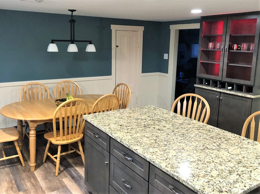 Photo of a mid-sized transitional l-shaped eat-in kitchen in Boston with an undermount sink, shaker cabinets, grey cabinets, granite benchtops, stainless steel appliances, vinyl floors, with island, brown floor and beige benchtop.