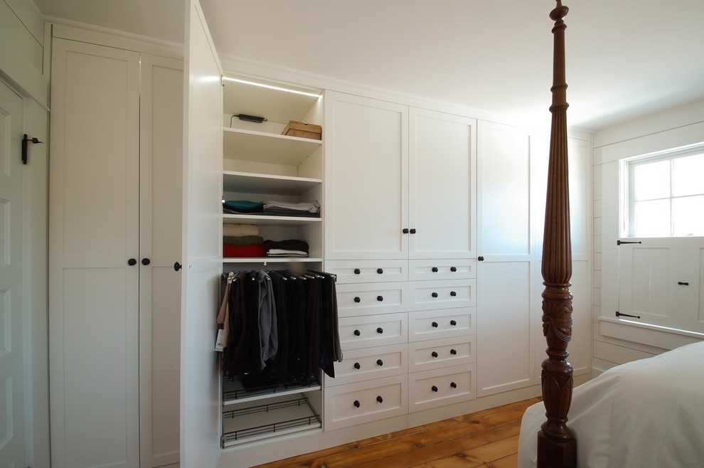 Mid-sized traditional gender-neutral dressing room in Minneapolis with shaker cabinets, white cabinets and medium hardwood floors.