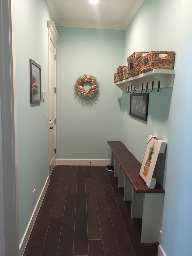 Photo of a mid-sized beach style hallway in Miami with blue walls, dark hardwood floors and brown floor.