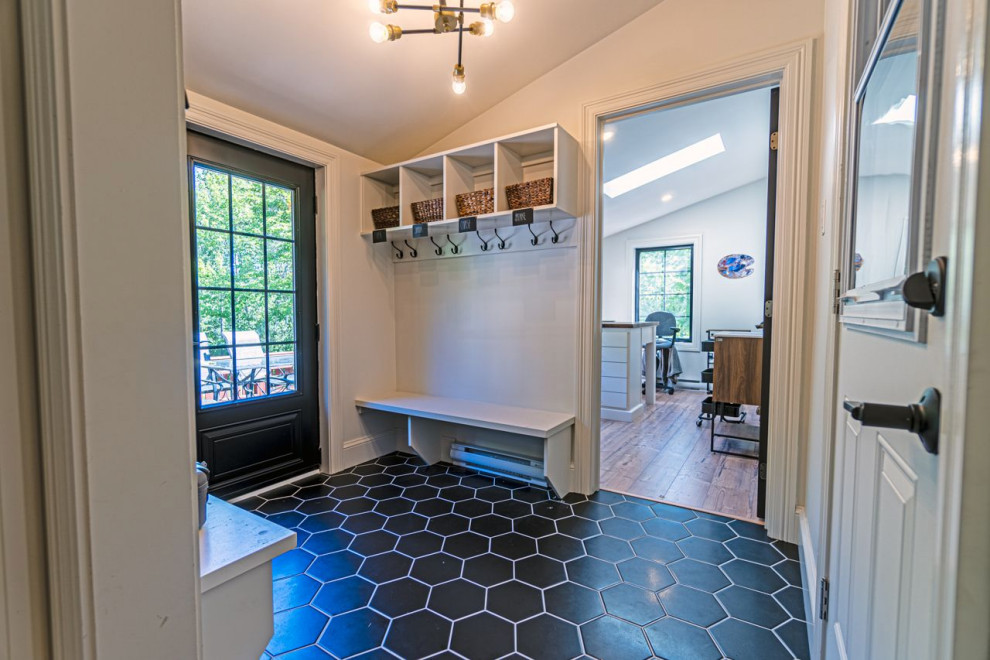 Inspiration for a mid-sized eclectic ceramic tile and black floor mudroom remodel with white walls