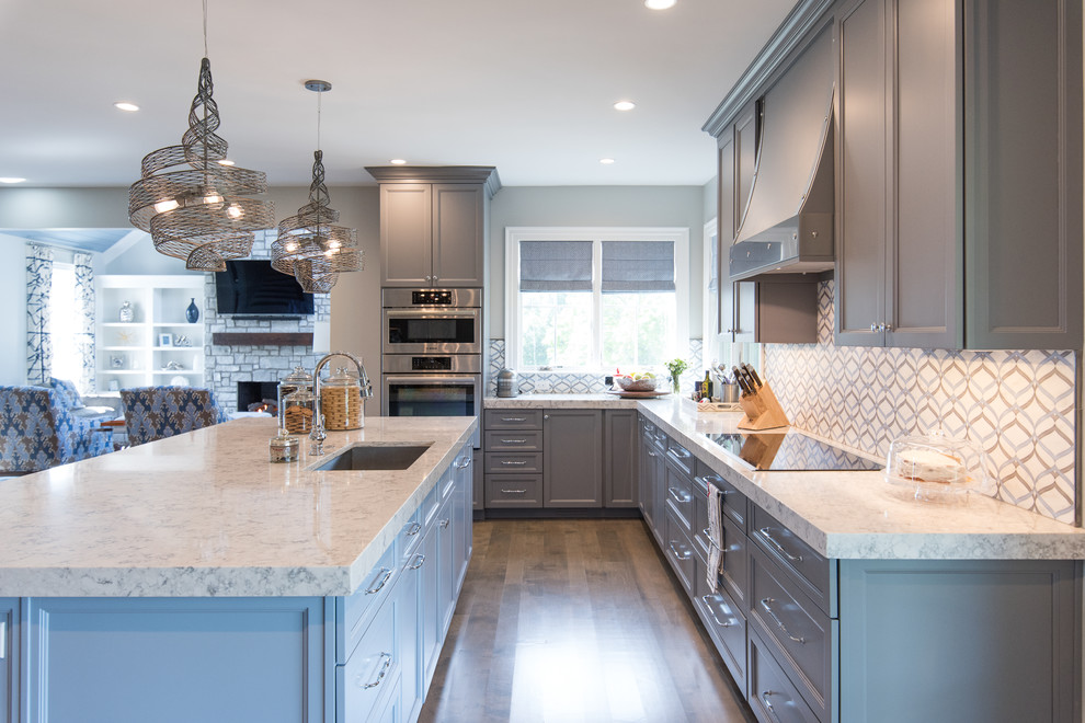 Inspiration for a large transitional medium tone wood floor eat-in kitchen remodel with a single-bowl sink, shaker cabinets, gray cabinets, quartz countertops, multicolored backsplash, marble backsplash and paneled appliances