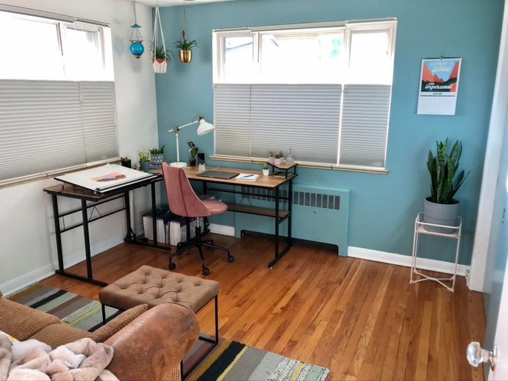 Home studio - transitional freestanding desk medium tone wood floor and brown floor home studio idea in Denver with multicolored walls