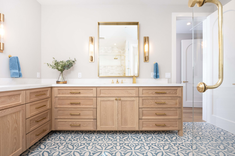 Photo of a large mediterranean master bathroom in San Francisco with shaker cabinets, medium wood cabinets, a double shower, a bidet, white tile, marble, beige walls, cement tiles, an undermount sink, engineered quartz benchtops, blue floor, a hinged shower door, white benchtops, a shower seat, a double vanity and a freestanding vanity.
