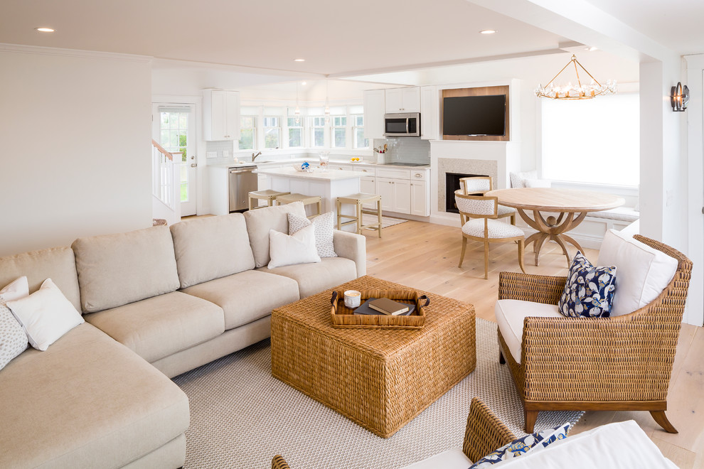 Design ideas for a mid-sized beach style open concept living room in Providence with white walls, light hardwood floors, a standard fireplace, a stone fireplace surround and a wall-mounted tv.