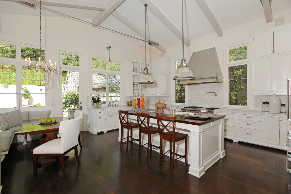 Photo of a traditional eat-in kitchen in Los Angeles with a farmhouse sink, shaker cabinets, white cabinets, white splashback and stainless steel appliances.