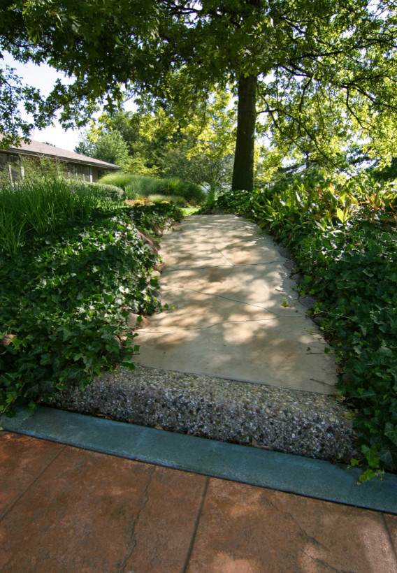 This is an example of a small front yard garden in Chicago with concrete pavers.