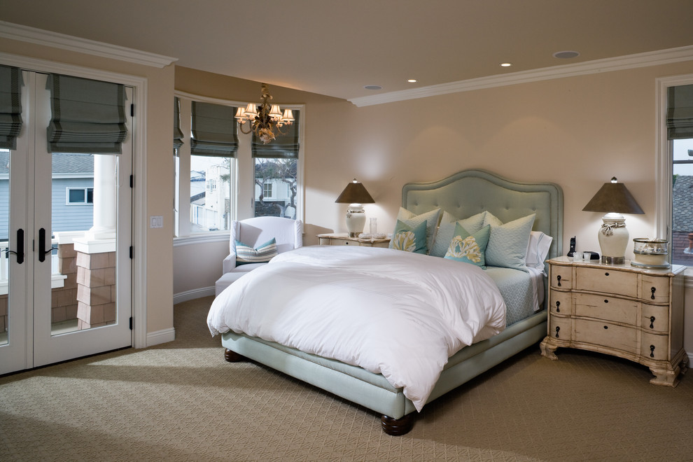 Design ideas for a beach style bedroom in Orange County with beige walls and carpet.