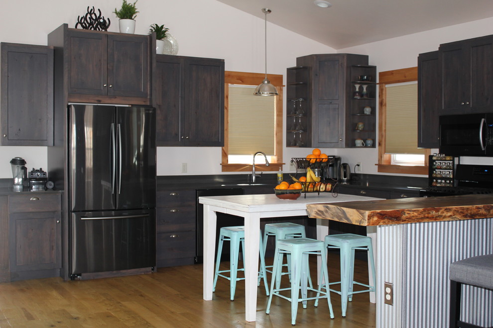 Open concept kitchen - large transitional u-shaped light wood floor and brown floor open concept kitchen idea with shaker cabinets, dark wood cabinets, an island and black countertops