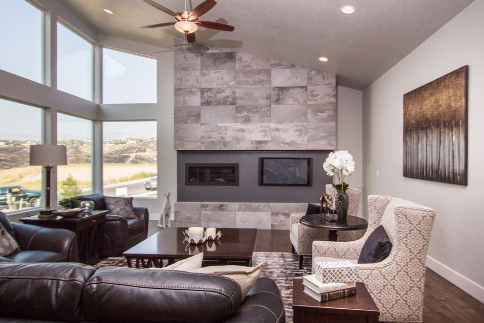 This is an example of a mid-sized contemporary formal open concept living room in Boise with grey walls, medium hardwood floors, a ribbon fireplace, a metal fireplace surround, a built-in media wall and brown floor.