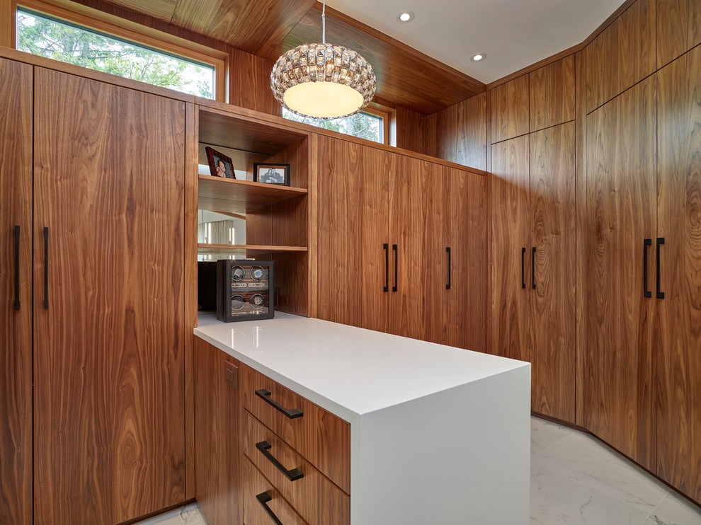 Photo of an expansive contemporary gender-neutral walk-in wardrobe in Calgary with flat-panel cabinets, medium wood cabinets and marble floors.