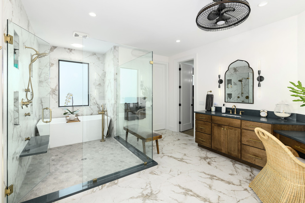 Large transitional master white tile and porcelain tile porcelain tile, white floor and double-sink freestanding bathtub photo in Jacksonville with shaker cabinets, medium tone wood cabinets, a one-piece toilet, white walls, an undermount sink, quartz countertops, a hinged shower door, gray countertops and a built-in vanity
