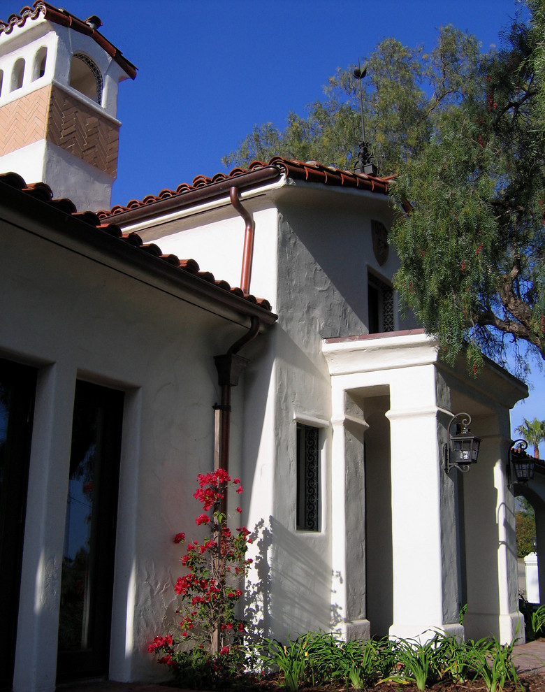 Photo of a mid-sized mediterranean front door in Santa Barbara with white walls, a single front door, a metal front door, brick floors and red floor.