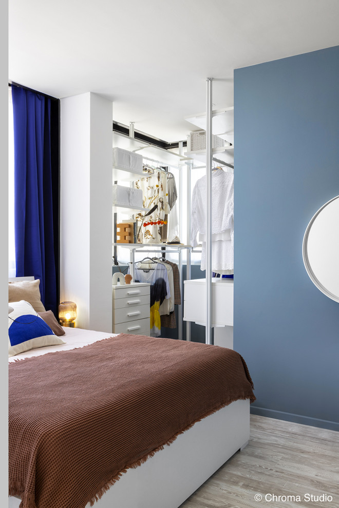 Idee per una camera matrimoniale minimal di medie dimensioni con pareti blu, parquet chiaro e pavimento bianco